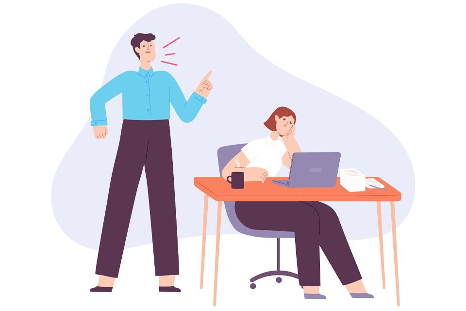 A man and woman collaborate at a desk, focused on their work with papers and a laptop in front of them.